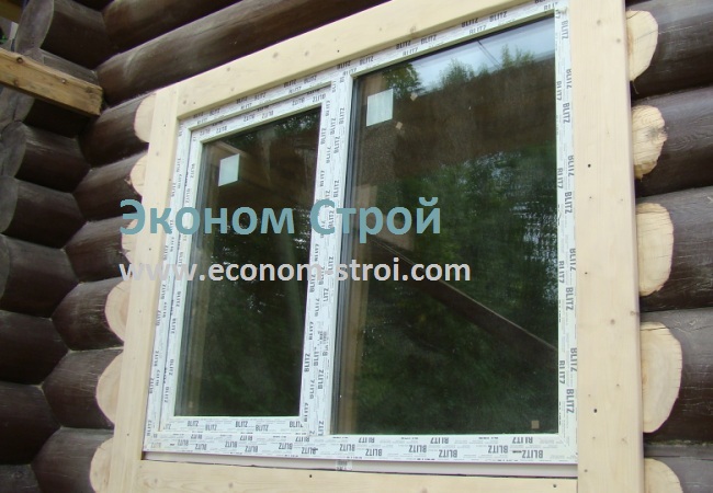 на фото установленное окно в доме из бревна с зарубиной
